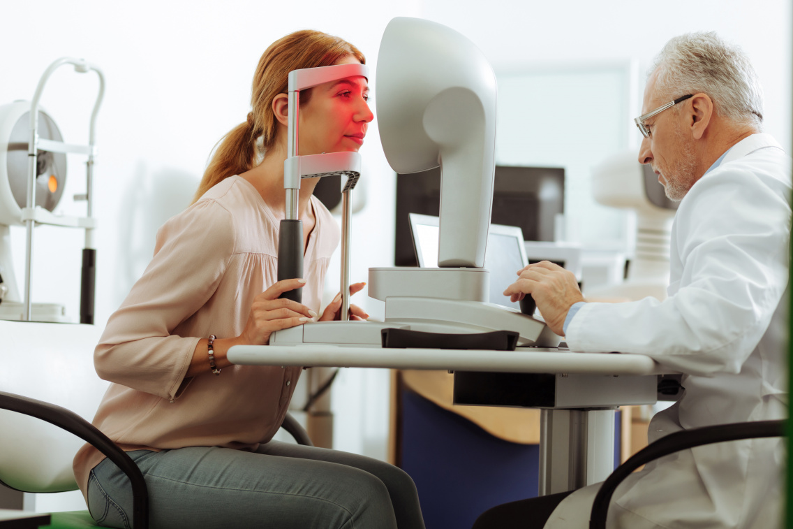 Consultație oftalmologică &mdash; medic examin&acirc;nd ochiul unui pacient